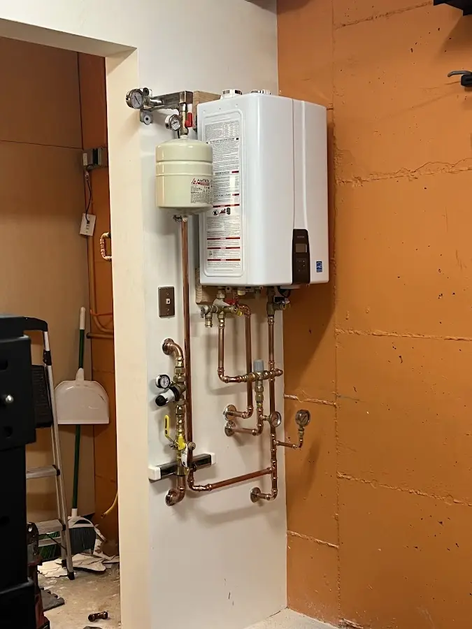 Plumbing technician inspecting water heater connections in Valle Vista